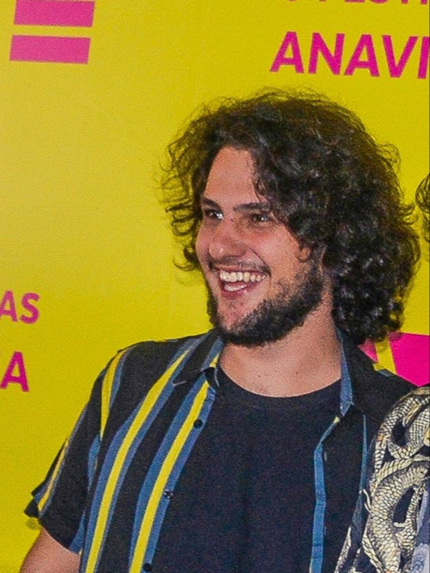 Zani sorrindo, de camiseta cinza com mangas pretas